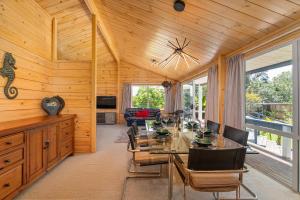 a dining room with a glass table and chairs at Sea Breezes in Matarangi