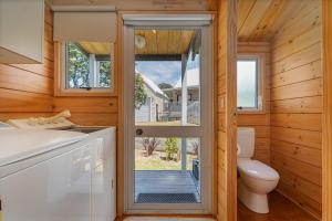 a small bathroom with a toilet and a window at Sea Breezes in Matarangi +15 photos