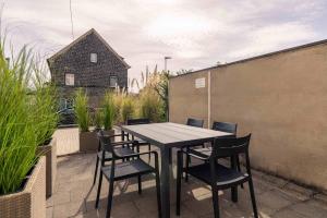 a table and chairs on a patio with a house at Laacher-Loft Ferienwohnung in Mendig