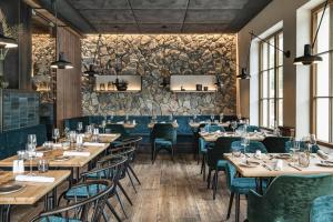 a restaurant with tables and chairs and a stone wall at Blauer Bock in Passau