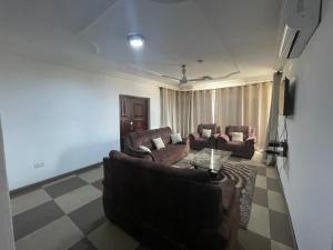 a living room with two couches and a tv at Hallmark Apartments -1 in Accra