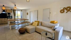 a living room with a couch and a table at Le Refuge de Coccinette in Essey
