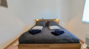 a bedroom with a bed with two pillows on it at Le Refuge de Coccinette in Essey