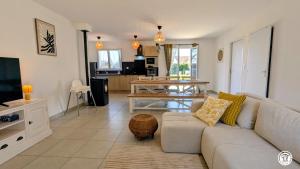 a living room with a couch and a table at Le Refuge de Coccinette in Essey