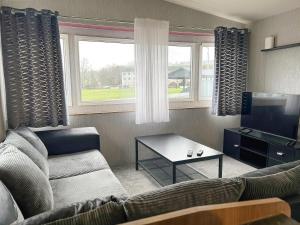 a living room with a couch and a tv at The Rowan - Uk51410 in Brechin
