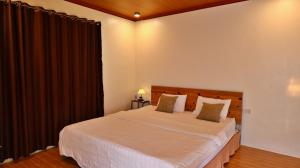 a bedroom with a large white bed with black drapes at Trang An Pristine View Homestay in Ninh Binh