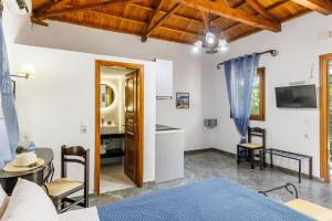 a bedroom with a bed and a table and chairs at Artemis Bungalows in Stafylos