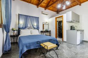 a bedroom with a blue bed and a yellow chair at Artemis Bungalows in Stafylos