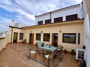 a patio with a table and chairs in front of a house at CasaManuelaMonesterio in Monesterio