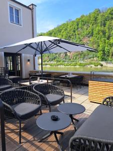 a patio with tables and chairs and an umbrella at Blauer Bock in Passau +4 photos