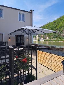 a patio with an umbrella next to a river at Blauer Bock in Passau