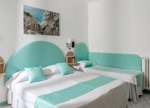 two beds in a room with blue and white at Hotel Carmencita in Anacapri