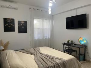 a bedroom with a bed and a desk and a television at Appartamento in villa in Torre a Mare