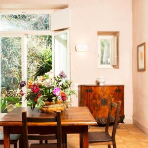 a dining room table with a basket of flowers on it at Baia delle Rocce Verdi Resort in Naples