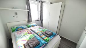 a small bedroom with a bed with colorful sheets at PONTUS Ferienwohnung FeWo 1 in Zislow