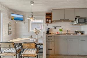 a kitchen with a table and chairs and a sink at Hausboot "Mien Schipp" mit Sonnendeck im Yachthafen in Fehmarn +18 photos
