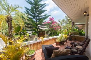a patio with chairs and a palm tree on a balcony at Southern Lanta A4 in Ko Lanta