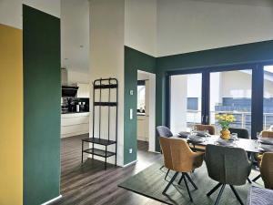 a dining room with a table and chairs and a kitchen at Luxus-Penthouse mit einzigartigem Schlossblick in Bad Berleburg