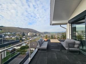 a balcony with two chairs and a table on a roof at Luxus-Penthouse mit einzigartigem Schlossblick in Bad Berleburg