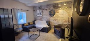 a living room with a couch and a chair at Le Relais de la Comté in Portbail