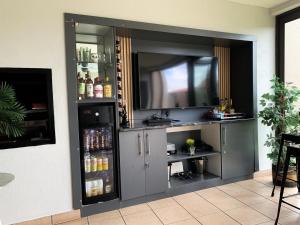 a entertainment center with a television in a room at Lekoa Lifestyle Apartment in Vanderbijlpark