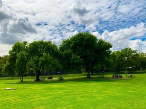 a park with benches and trees in a field at Lekoa Lifestyle Apartment in Vanderbijlpark