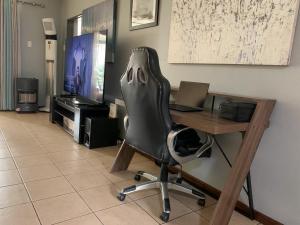 a office with a desk with a chair and a laptop at Lekoa Lifestyle Apartment in Vanderbijlpark