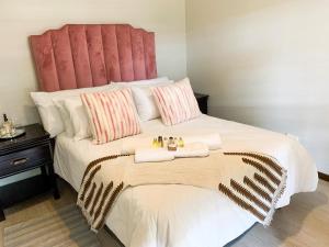 a bedroom with a large white bed with two towels at Lekoa Lifestyle Apartment in Vanderbijlpark