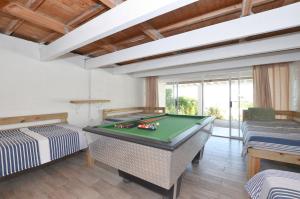 a billiard room with a pool table andwindows at Kommaweer in Yzerfontein