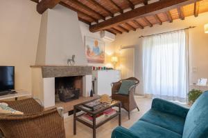 a living room with a blue couch and a fireplace at Borgo La Fonte - Together in Tuscany in Cortona