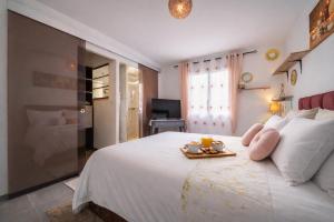 a bedroom with a white bed with a tray of food on it at Loge au ptitbonheur in Savasse +55 photos