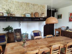 a dining room with a wooden table and chairs at "Hertou" in Clèdes +57 photos