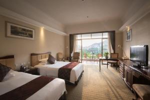 Habitación de hotel con 2 camas y TV de pantalla plana. en Guangzhou Phoenix City Hotel, en Zengcheng