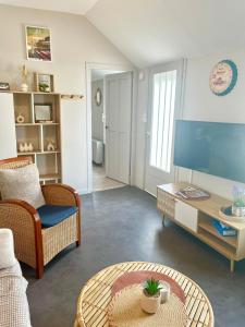 a living room with a tv and a table at Le Refuge du Mans in Le Mans