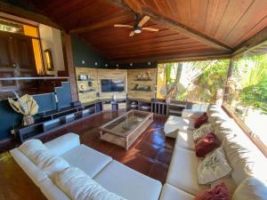 a living room with white couches and a ceiling at FERRADURA EXCLUSIVE SEaVIEW in Búzios