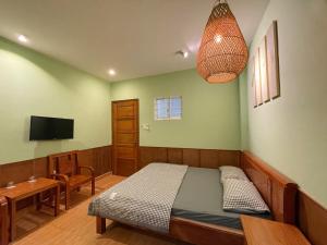 a bedroom with a bed and a table and a television at 5 homestay central in Vung Tau