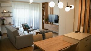 a living room with a dining room table and a television at Apartman Jančić in Loznica