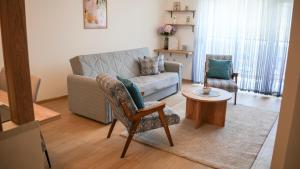 a living room with a couch and two chairs and a table at Apartman Jančić in Loznica