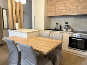 a kitchen with a wooden table and chairs at Apartman Jančić in Loznica
