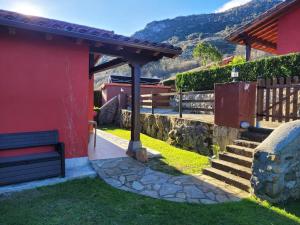 a red house with a bench next to a staircase at La Casuca in Celucos
