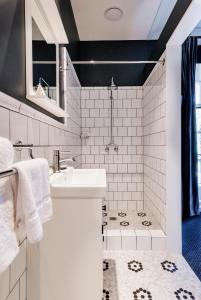 a white bathroom with a sink and a shower at The North Sydney Hotel in Sydney