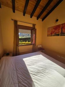 a bedroom with a white bed and a window at La Casuca in Celucos