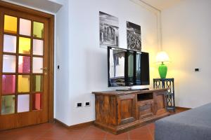 a living room with a television on a wooden cabinet at Casa Garibaldi con Terrazzo e Parking, Mare 1 min in San Vincenzo