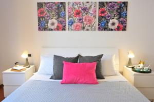 a bedroom with a bed with a pink pillow at Casa Garibaldi con Terrazzo e Parking, Mare 1 min in San Vincenzo