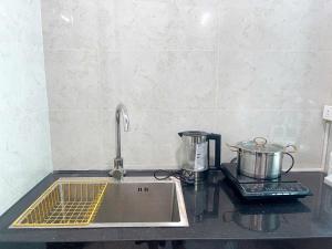 a kitchen counter with a sink and a stove at CH home apartment in Hanoi