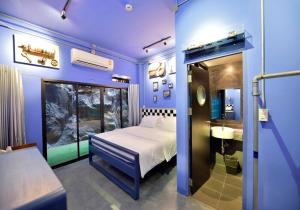 ein blaues Zimmer mit einem Bett und einem Aquarium in der Unterkunft Jasaen Hotel in Godown