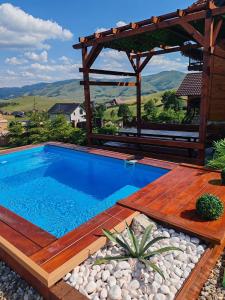 a swimming pool with a wooden deck and a pergola at Rustic dream MIA in Zlatibor