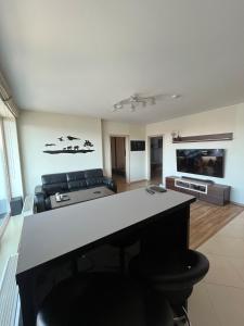 a living room with a table and a couch at Spacious Apartment with 2 Balconies in Klaipėda