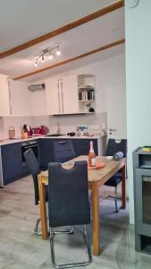 a kitchen with a wooden table and chairs at PONTUS Ferienwohnung FeWo2 in Zislow +35 photos