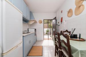 a kitchen with white cabinets and a table and chairs at Peaceful Retreat near Sesimbra and Meco Beach - MADA HOUSE's II in Sesimbra